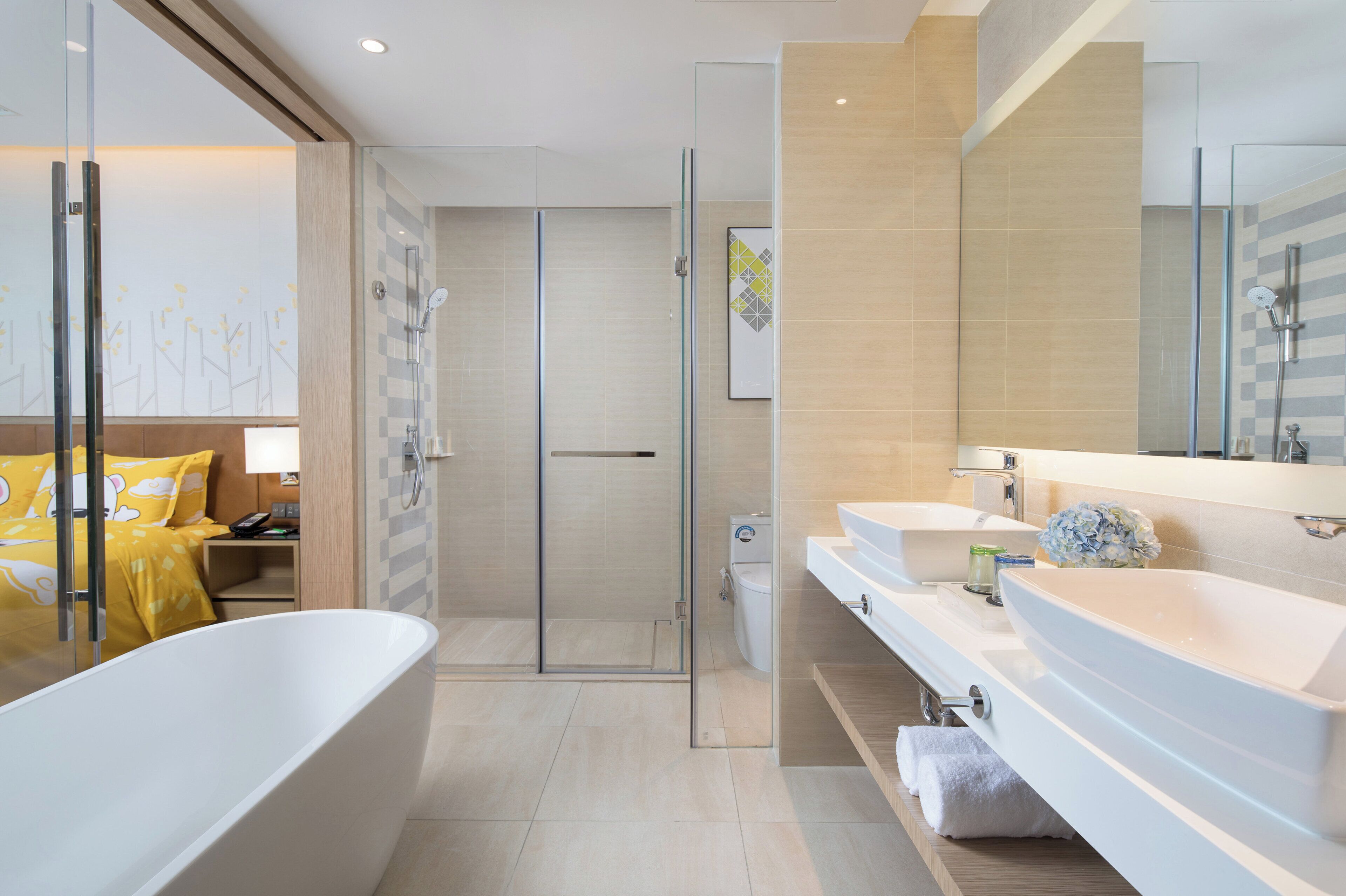 Une salle de bain moderne avec une baignoire sur pieds, une douche à parois de verre et un meuble-lavabo doté d’un grand miroir.