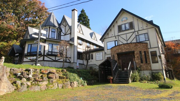 A large, historic building with multiple stories, a stone facade, and a prominent entrance with steps. - Petit Resort Hotel Der Barte (Yamagata)