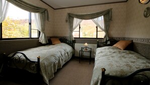 A room with two single beds, a small table, and a radiator. - Petit Resort Hotel Der Barte (Yamagata)