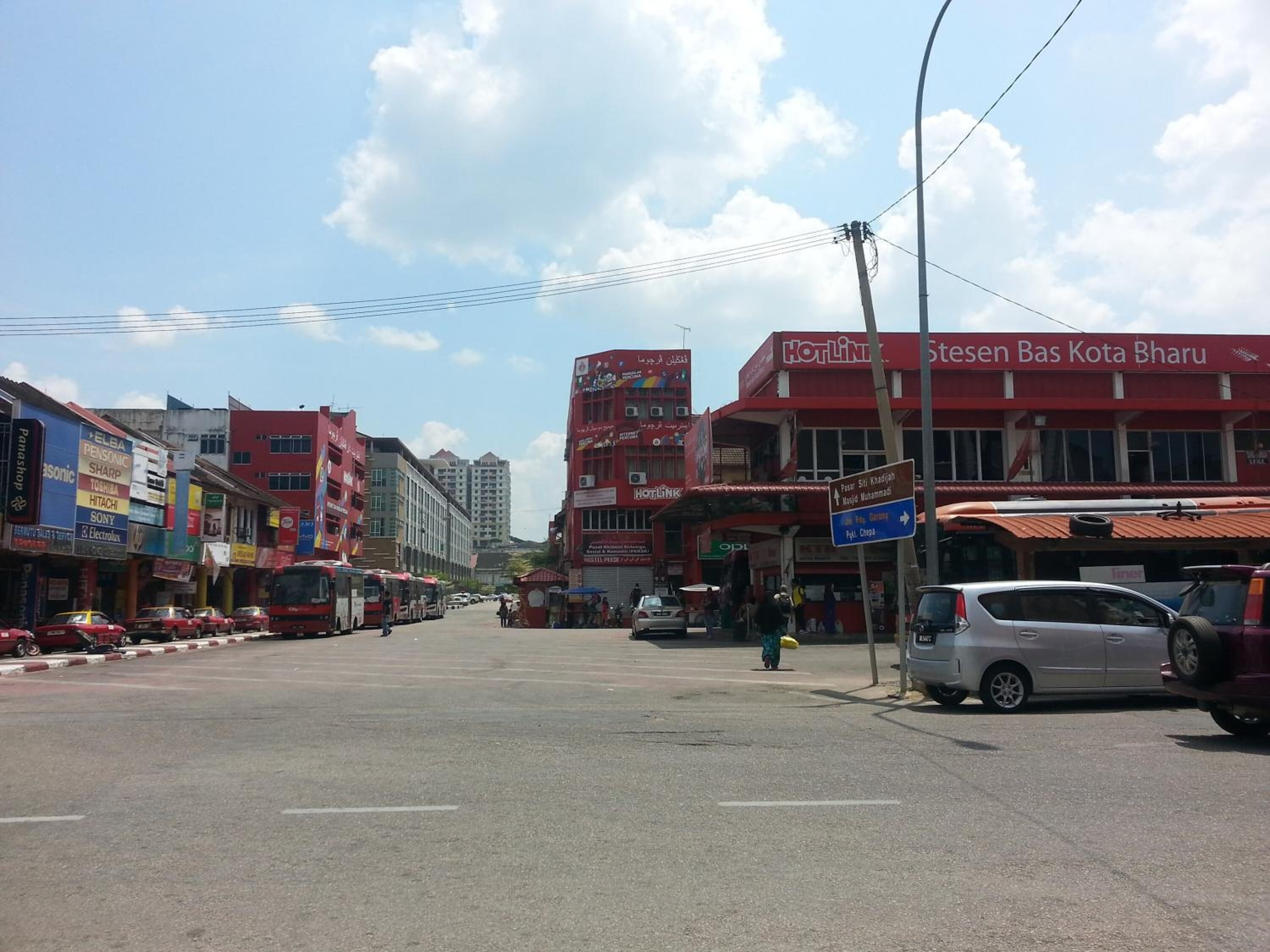 A street with buildings, including a red building with 'Hotline' signage.