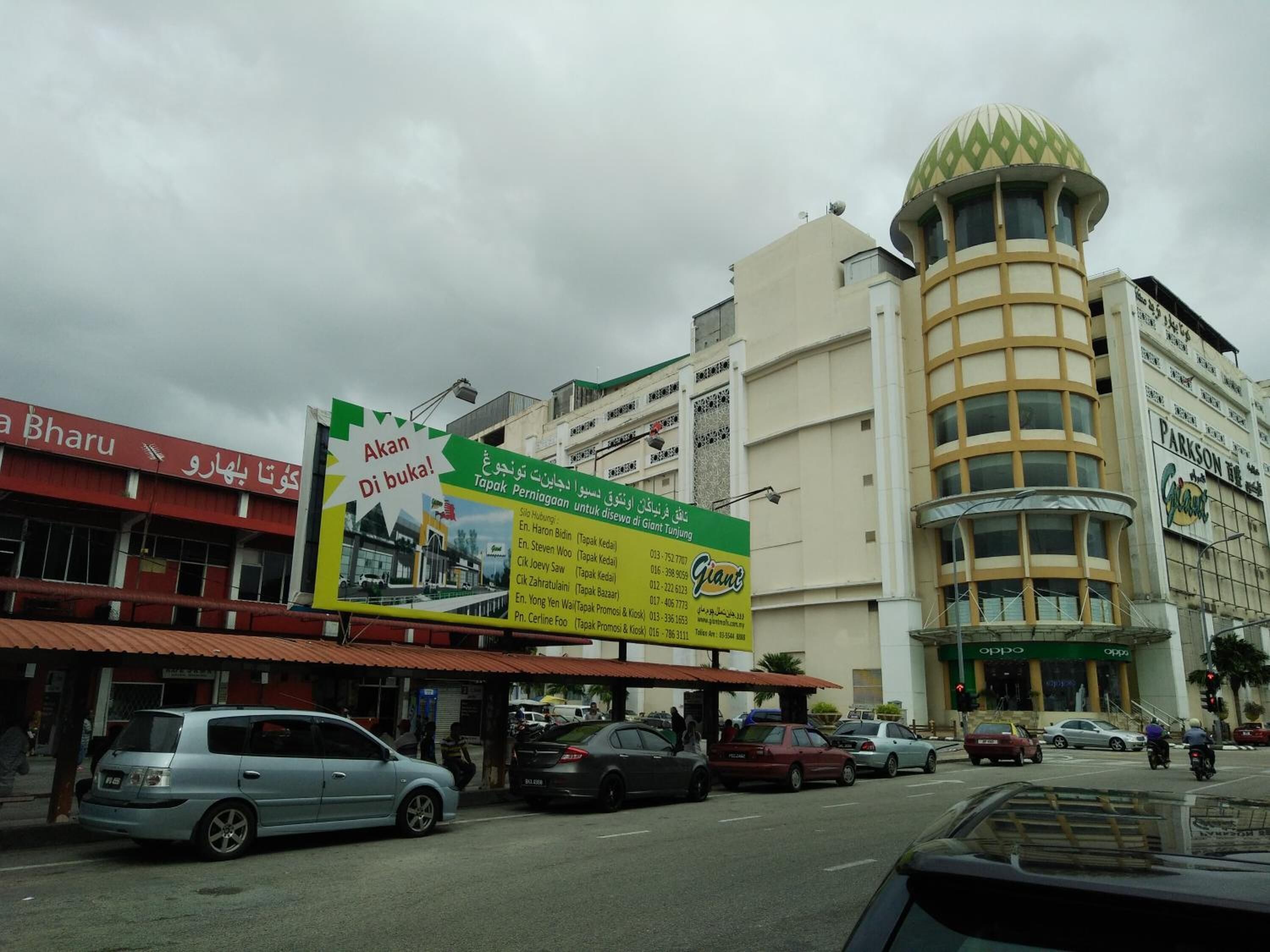 A street view with a large billboard advertising a hotel.