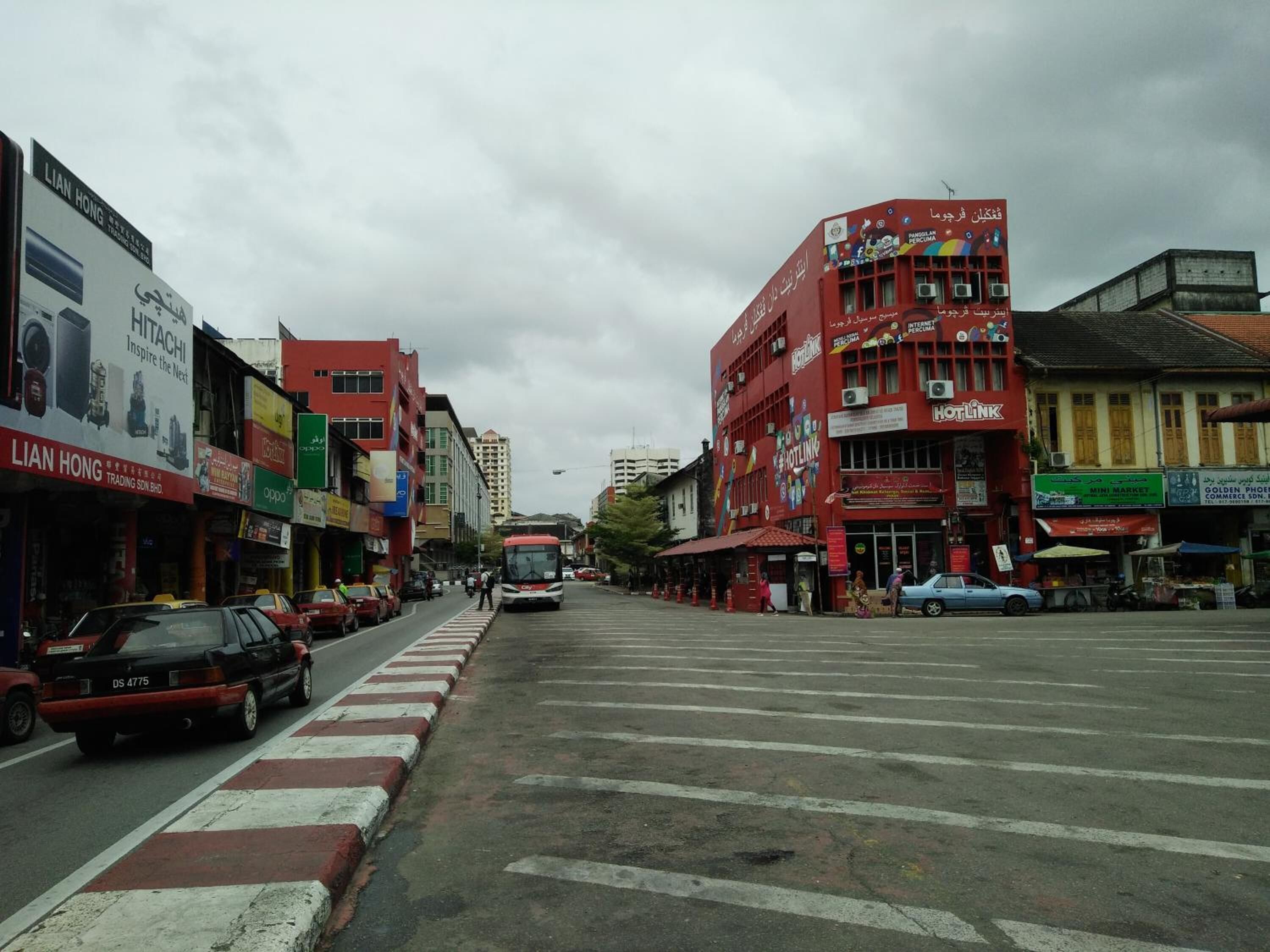 Una calle con edificios, un autobús y automóviles.