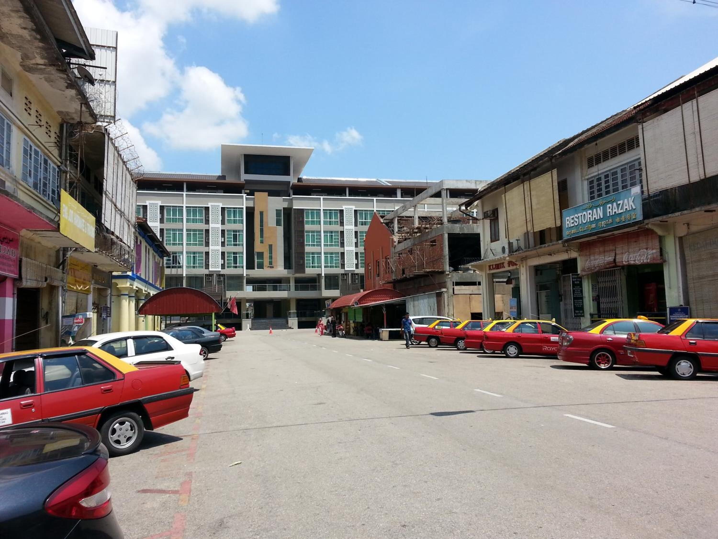 A street with multiple cars parked on the side.