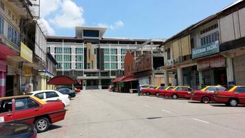 A street with multiple cars parked on the side.