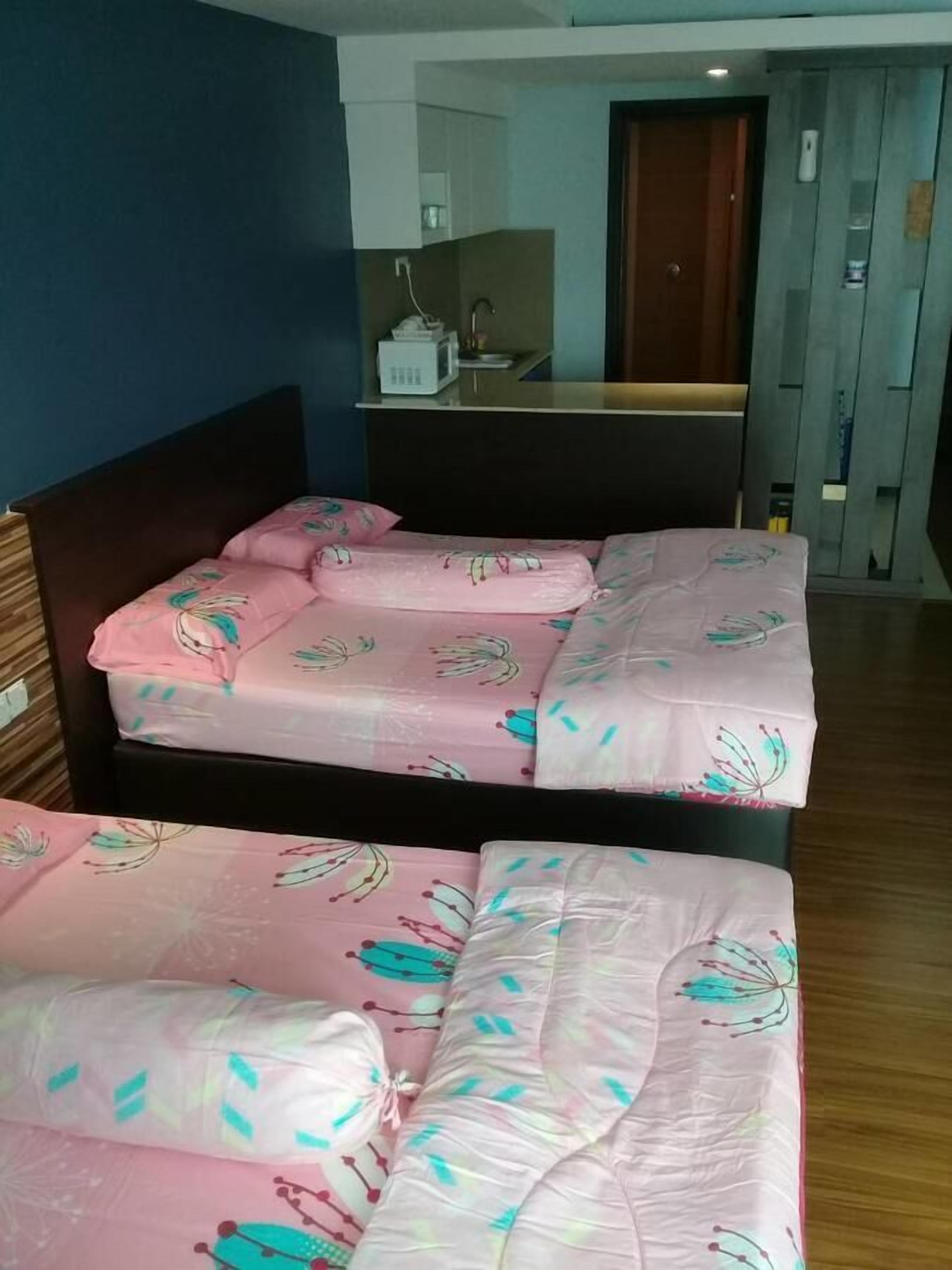 A double bed with floral bedding, a wooden headboard, and a small bedside table with a lamp.