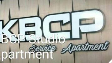 Un letrero con el texto 'KBCP Studio Service Apartment'.