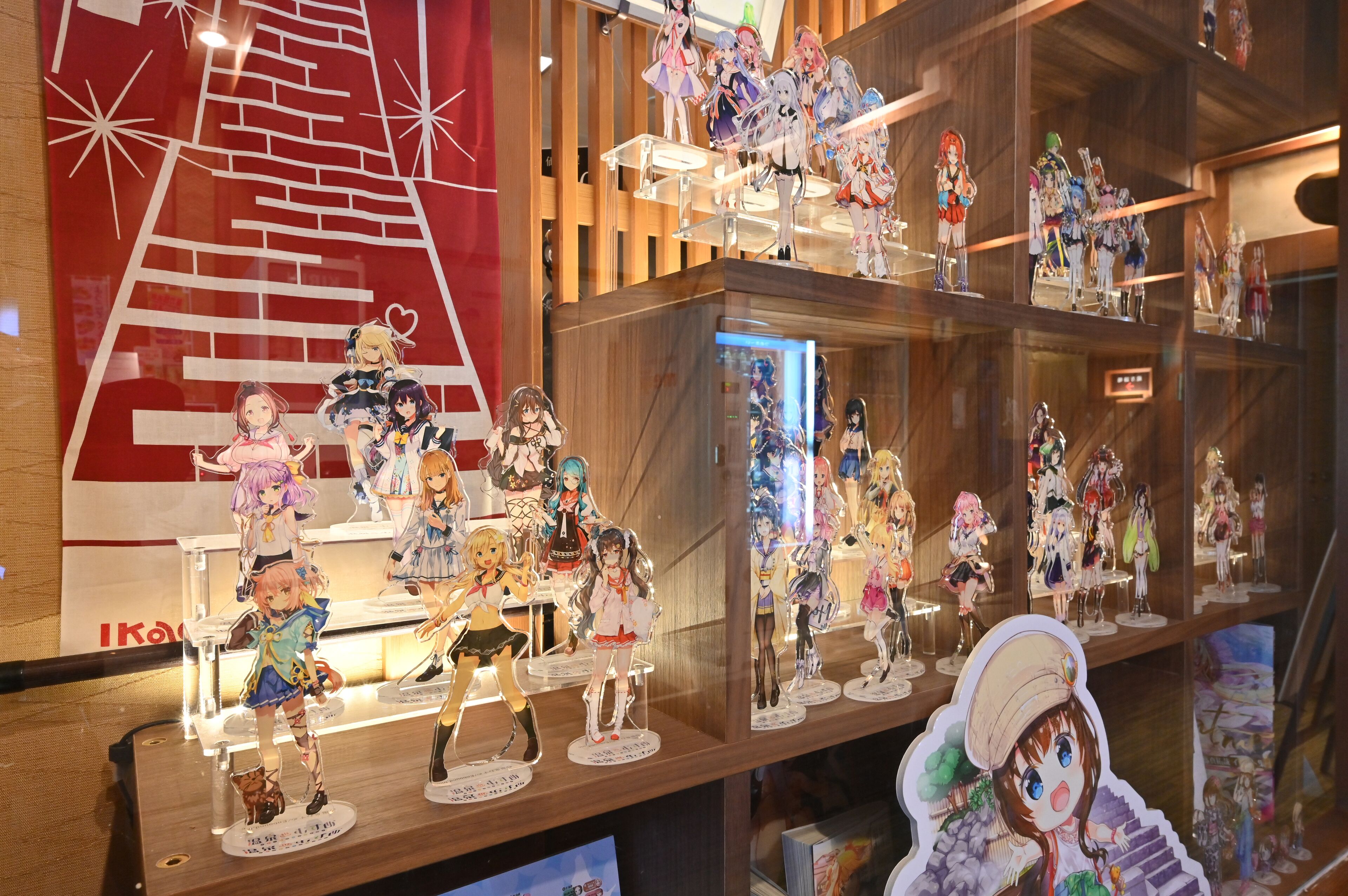 Una exhibición de varias figuras de anime en estanterías.