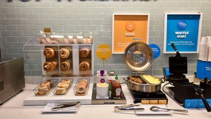 Een ontbijtbuffet met aanduidingen voor eieren, wafels en bagels.