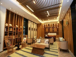Een modern interieur met een zithoek, houten boekenkasten en een vloerkleed met een patroon.