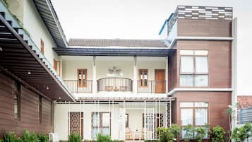 Un bâtiment à deux étages doté d’un balcon, d’une enseigne portant le nom « Beloaert » et d’un petit espace extérieur aménagé avec des sièges.