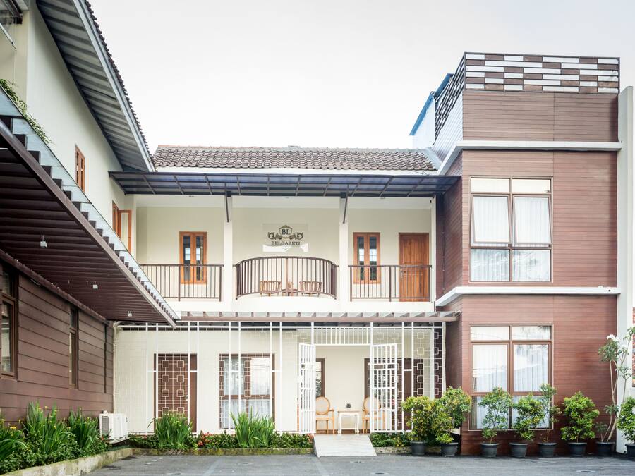 Un bâtiment à deux étages doté d’un balcon, d’une enseigne portant le nom « Beloaert » et d’un petit espace extérieur aménagé avec des sièges.