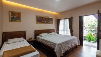 A bedroom with two beds, a wooden headboard, a nightstand, and a painting on the wall.