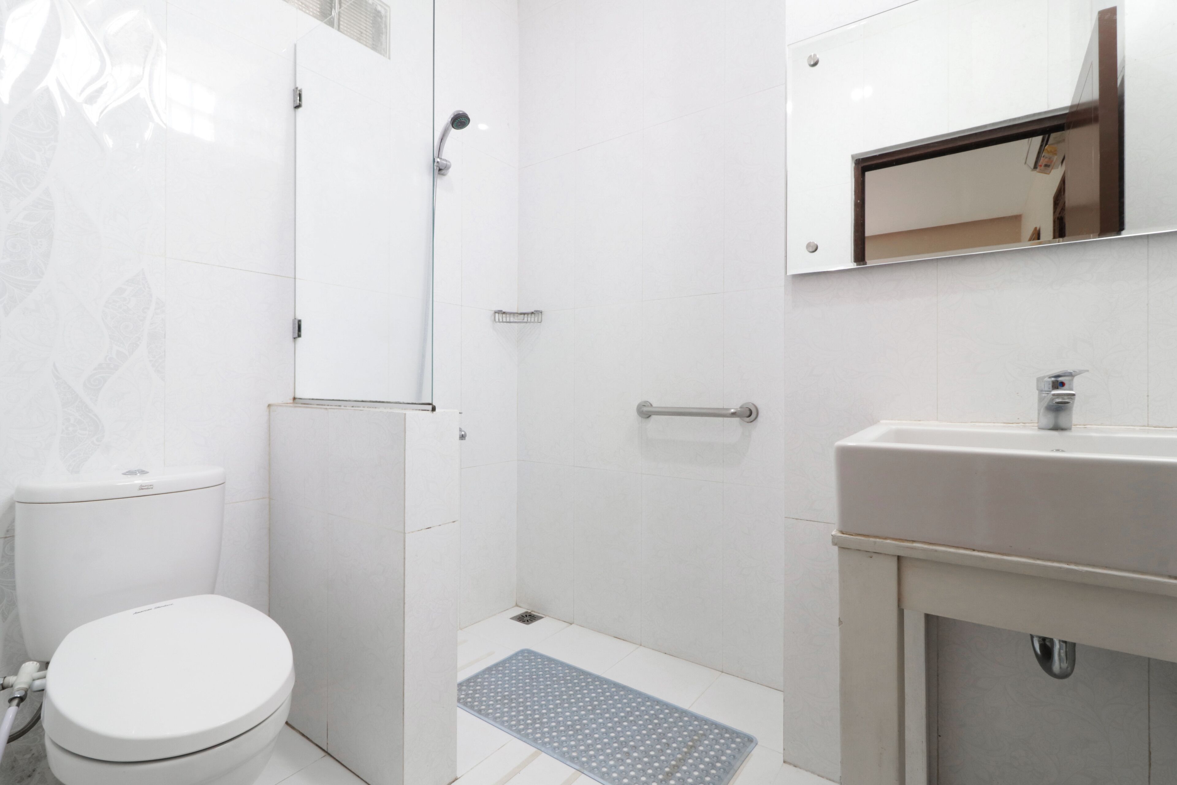 A bathroom with a toilet, shower, and sink.