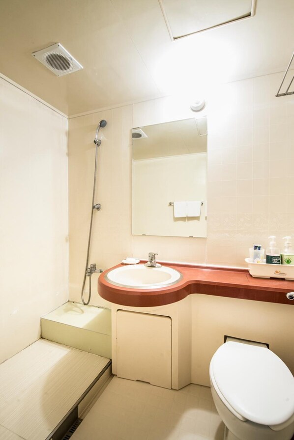 Un baño con ducha, lavamanos e inodoro.