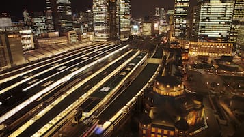 A nighttime cityscape with illuminated train tracks and modern buildings.