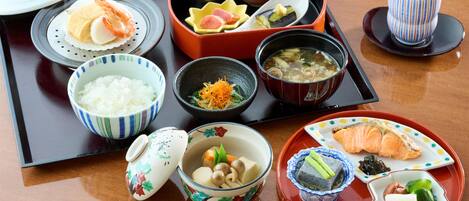 En traditionel japansk måltidsservering med ris, suppe og forskellige retter.