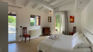 Une chambre à coucher comprenant un lit, une chaise, une petite armoire en bois et un radiateur.