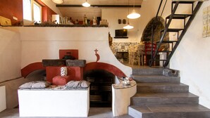 Un ambiente acogedor con una escalera, chimenea y zona de estar.