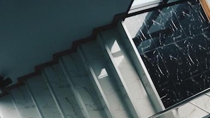 Eine Treppe mit Marmorstufen und Glasgeländern.