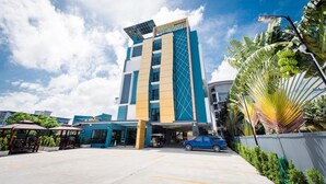 Ein Hotel mit modernem Design, gekennzeichnet durch einen auffälligen vertikalen Streifen und eine Solaranlage auf dem Dach.
