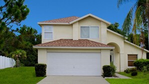 A two-story house with a single garage, a front porch, and a well-maintained lawn. - SUMMER SALE!!! - STUNNING VILLA, LARGE PRIVATE POOL & CONSERVATION VIEWS!! (Kissimmee)