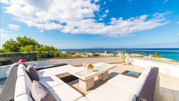 A rooftop terrace with a white sofa, a small table, and a view of the sea. - Luxury design villa with fantastic sea and mountain views (Betlem)