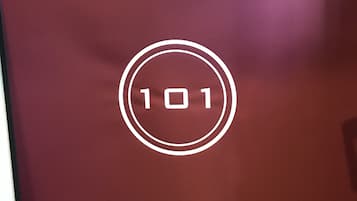A maroon-colored door with a white circular logo containing the number "101".