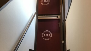 Un escalier menant à deux portes portant les numéros 101 et 106.