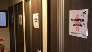 Un couloir avec des portes indiquant « Douches, réservées aux femmes ».