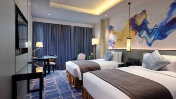A hotel room with two beds, a desk, a chair, and a large abstract painting on the wall.