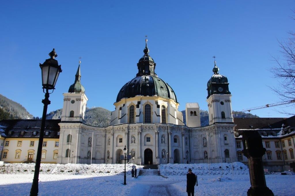A historic building with a large central dome and two smaller domes, surrounded by snow.