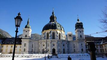 A historic building with a large central dome and two smaller domes, surrounded by snow.