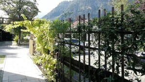 A pathway leading to a mountain view with a wooden fence and greenery. - 'Sissi' a charming apartment in a modern country house style (Oberammergau)