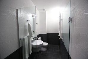 A compact bathroom with a toilet, sink, and glass shower enclosure. - Hotel Le Caucase (Tbilisi)