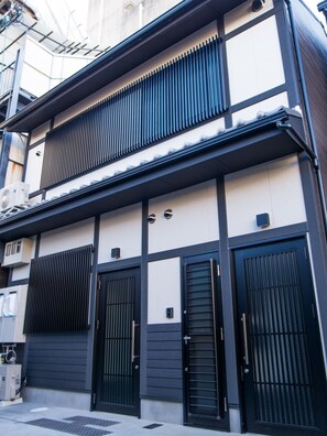 A traditional Japanese building with a black and white facade, featuring sliding doors and a tiled roof. - One More Heart at Kamishichiken 1 (Kyoto)