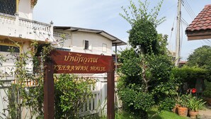 A sign for 'Keerawan House' with a white building in the background, surrounded by greenery and potted plants. - Keerawan House Rim Khong (Phon Phisai)