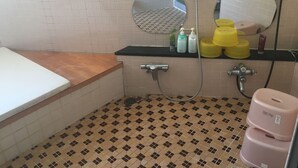 Ein Badezimmer mit Dusche, Toilette und Waschbecken. Auf der Ablage liegen Pflegeprodukte.