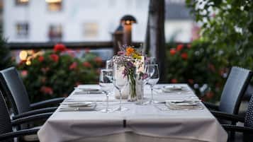 A table set for a meal with a white tablecloth, clear glassware, and a floral centerpiece.