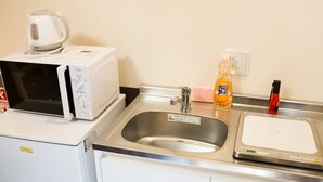 A kitchen with a microwave, a sink, a soap dispenser, and a red lighter. - One More Heart at Fushimi Inari 3 (Kyoto)