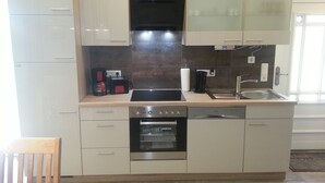 A modern kitchen with a built-in oven, dishwasher, and a stovetop. - Modern holiday house, relax in the countryside on one level (Karlshagen)