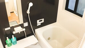 A modern bathroom with a bathtub, a toilet, a sink, and a mirror. - GH One More Heart at Toji 2 (Kyoto)