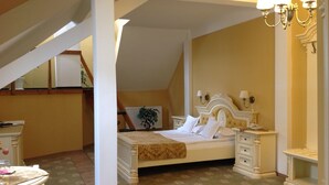 A bedroom with a bed, nightstands, a dresser, a chandelier, and a staircase. - Hotel Astoria (Satu Mare)