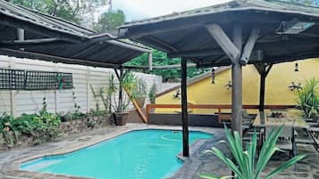 Una piscina al aire libre, tumbonas