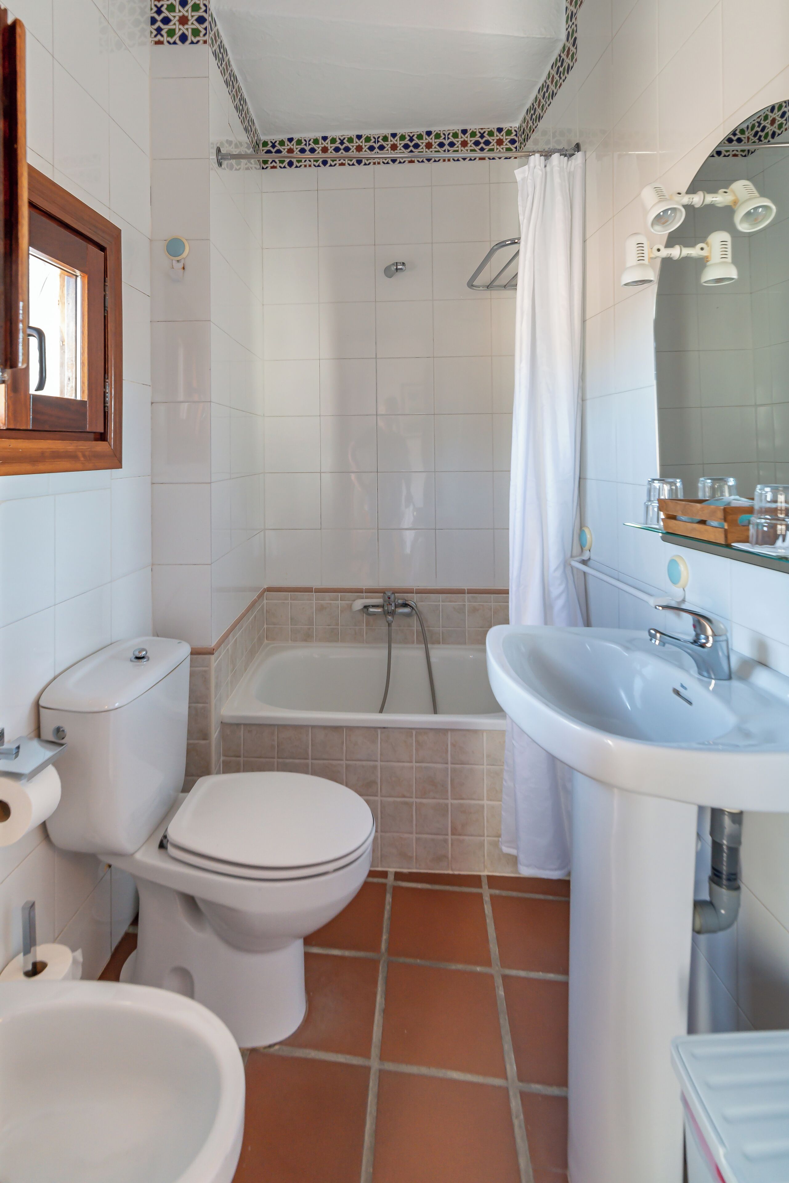 Een badkamer met toilet, bidet, bad en wastafel.