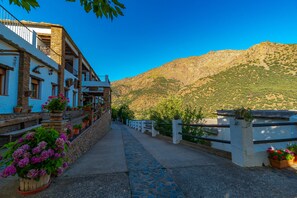 Una estrecha calle adoquinada con un edificio que tiene balcones y macetas.