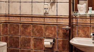 Een badkamer met toilet, wastafel en handdoekdispenser.