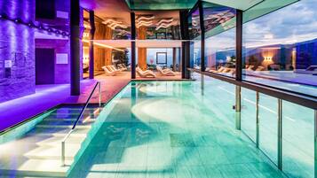 Alberca techada, alberca al aire libre y sombrillas en la alberca