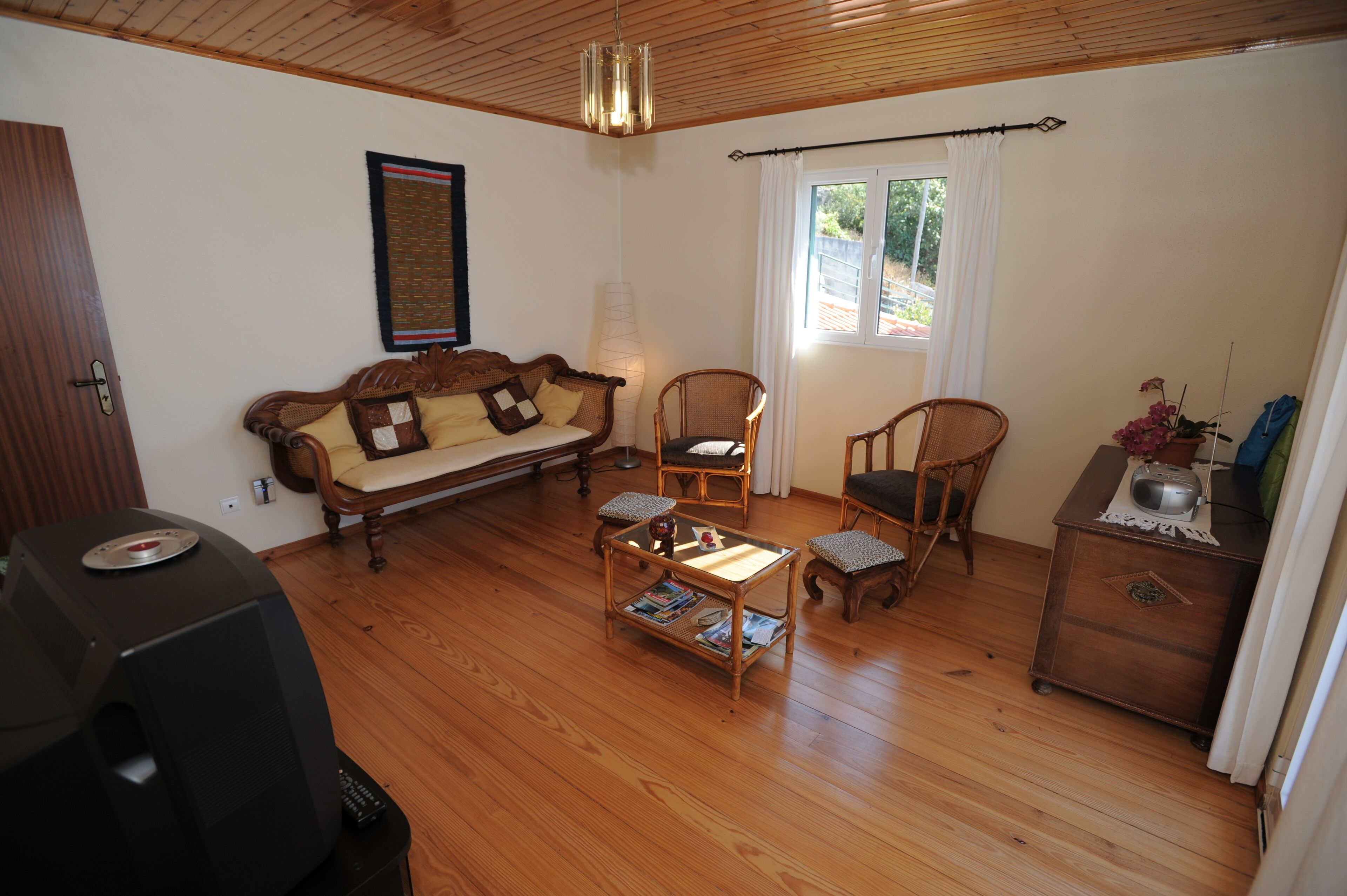 A living room with a sofa, two chairs, a coffee table, and a TV.