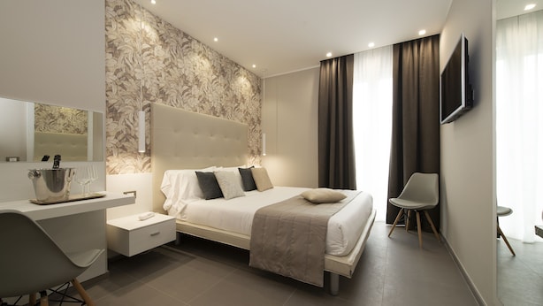 Un dormitorio moderno con una cama grande, un escritorio y un televisor.