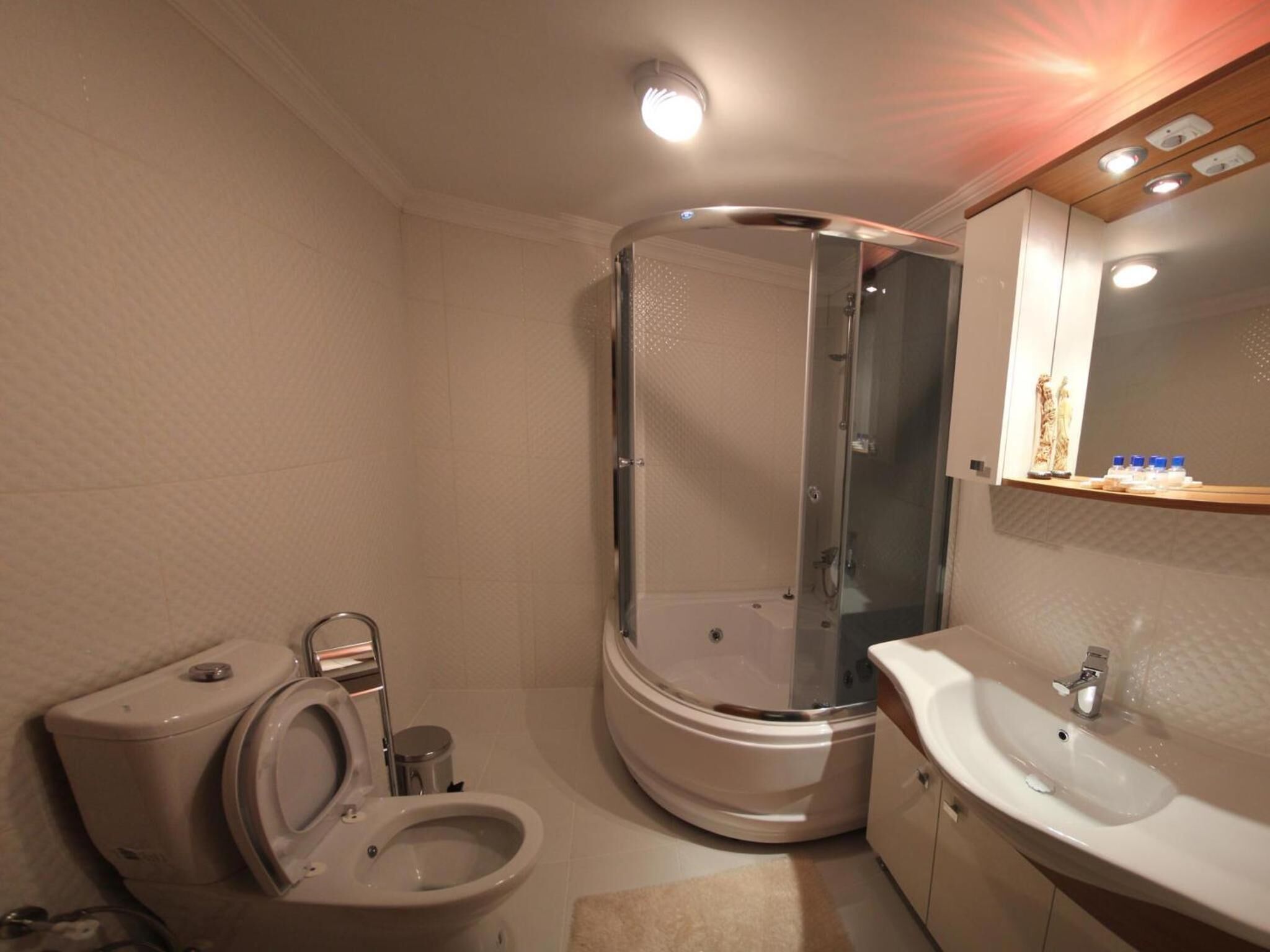 A bathroom with a toilet, a shower enclosure, and a sink.
